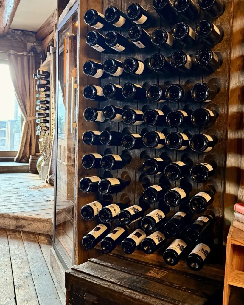 Wine bottles displayed in the wooden cellar at La Soucoupe Courchevel