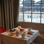 Elegant table setting beside a panoramic window at Le Chabichou Courchevel