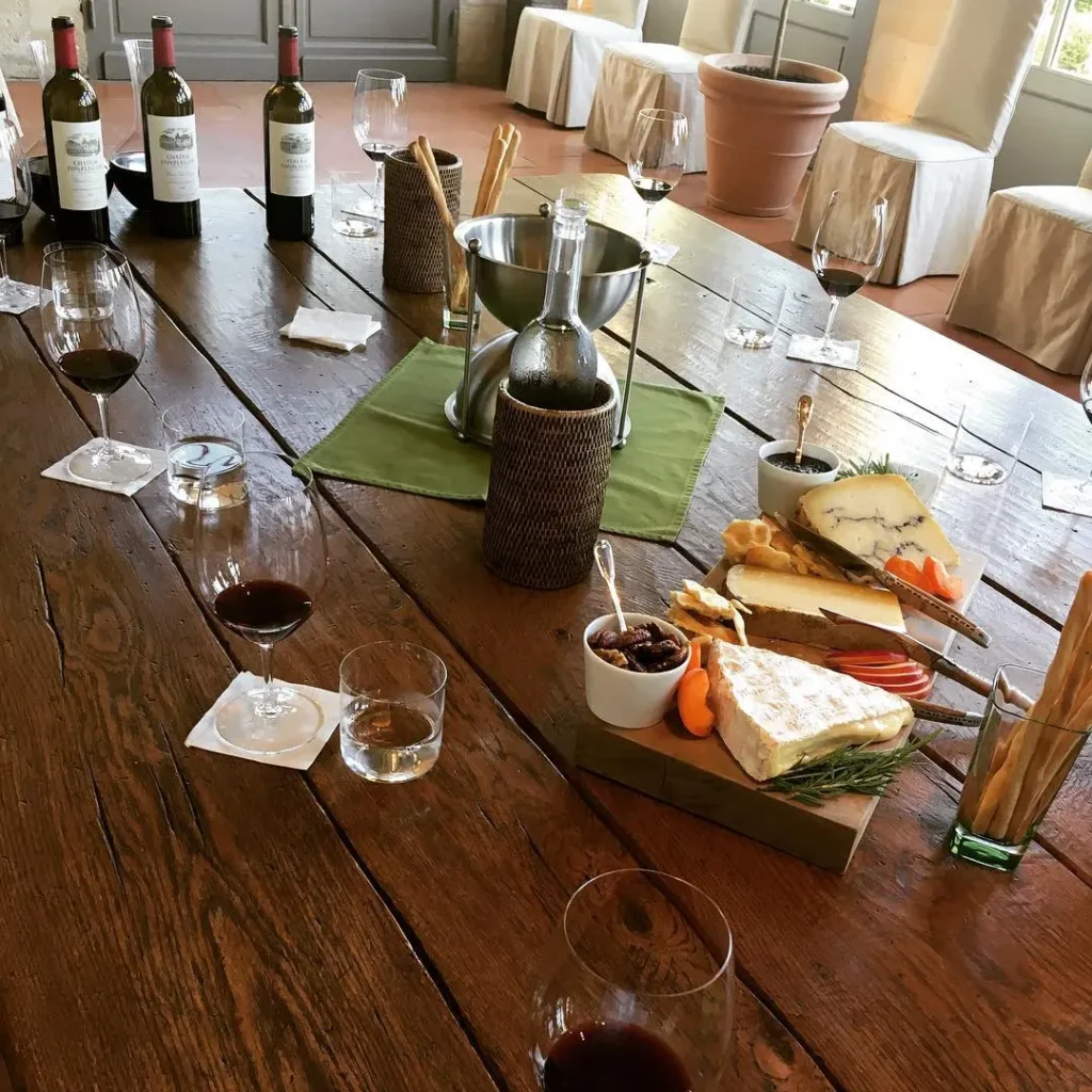 Wine and dishes arranged on a wooden dining table at Le Genepi Courchevel