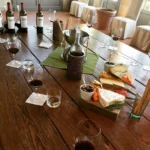 Wine and dishes arranged on a wooden dining table at Le Genepi Courchevel
