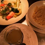 Dinner dishes and wine served at Le Genepi Courchevel