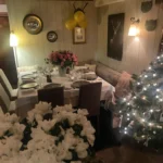 Festive dining room decorated with flowers and Christmas lights at Le Genepi Courchevel