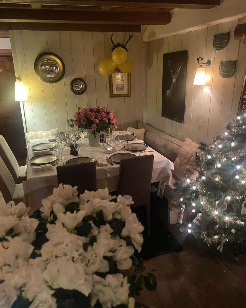 Festive dining room decorated with flowers and Christmas lights at Le Genepi Courchevel