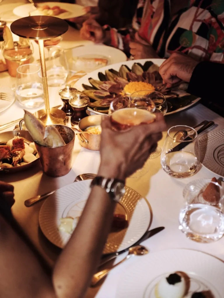 Guests enjoying drinks and dishes at Le Relais Plaza in Paris