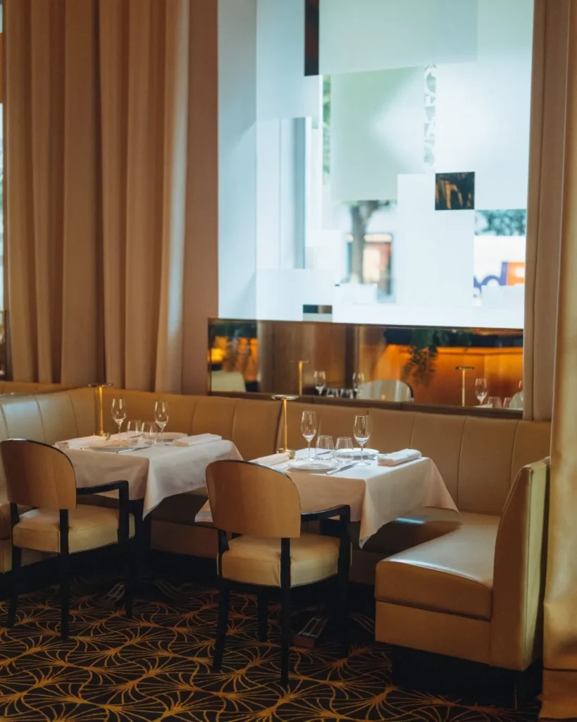 Elegant dining area with large windows at Le Relais Plaza in Paris