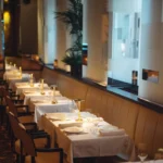 Elegant dining room with tables set at Le Relais Plaza in Paris