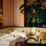 Bright dining room with elegant table settings at Le Relais Plaza in Paris