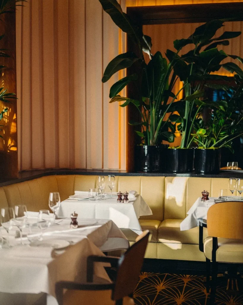 Bright dining room with elegant table settings at Le Relais Plaza in Paris