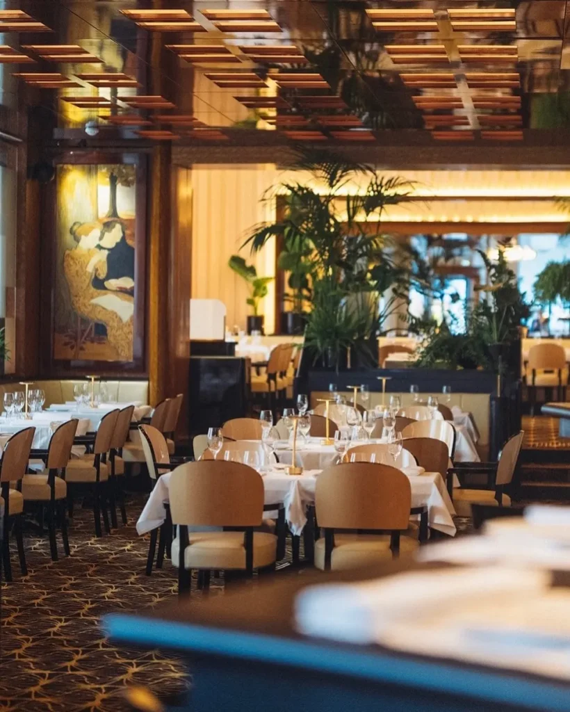 Warm wood-paneled dining room at Le Relais Plaza in Paris
