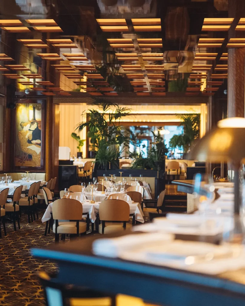 Warmly lit dining room at Le Relais Plaza in Paris