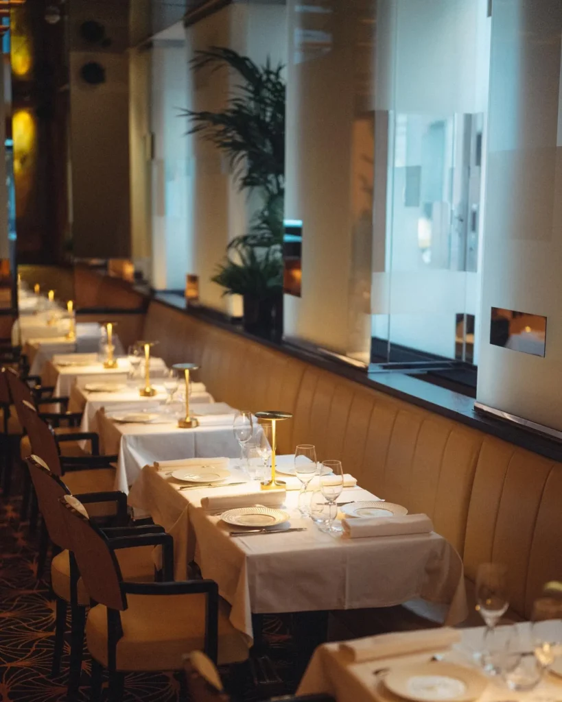 Elegant dining room with tables set at Le Relais Plaza in Paris