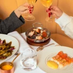 Elegant dining table with food and wine at Le Relais Plaza in Paris