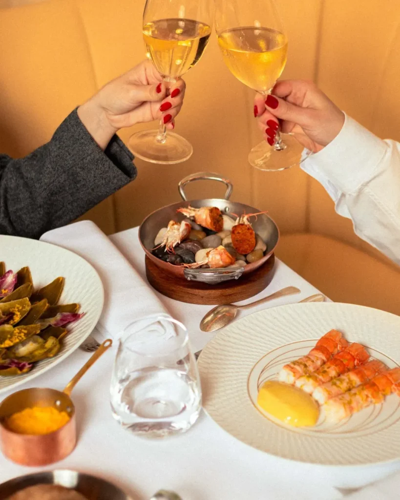 Elegant dining table with food and wine at Le Relais Plaza in Paris
