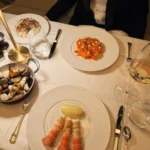 Elegant table setting with gourmet dishes at Le Relais Plaza in Paris
