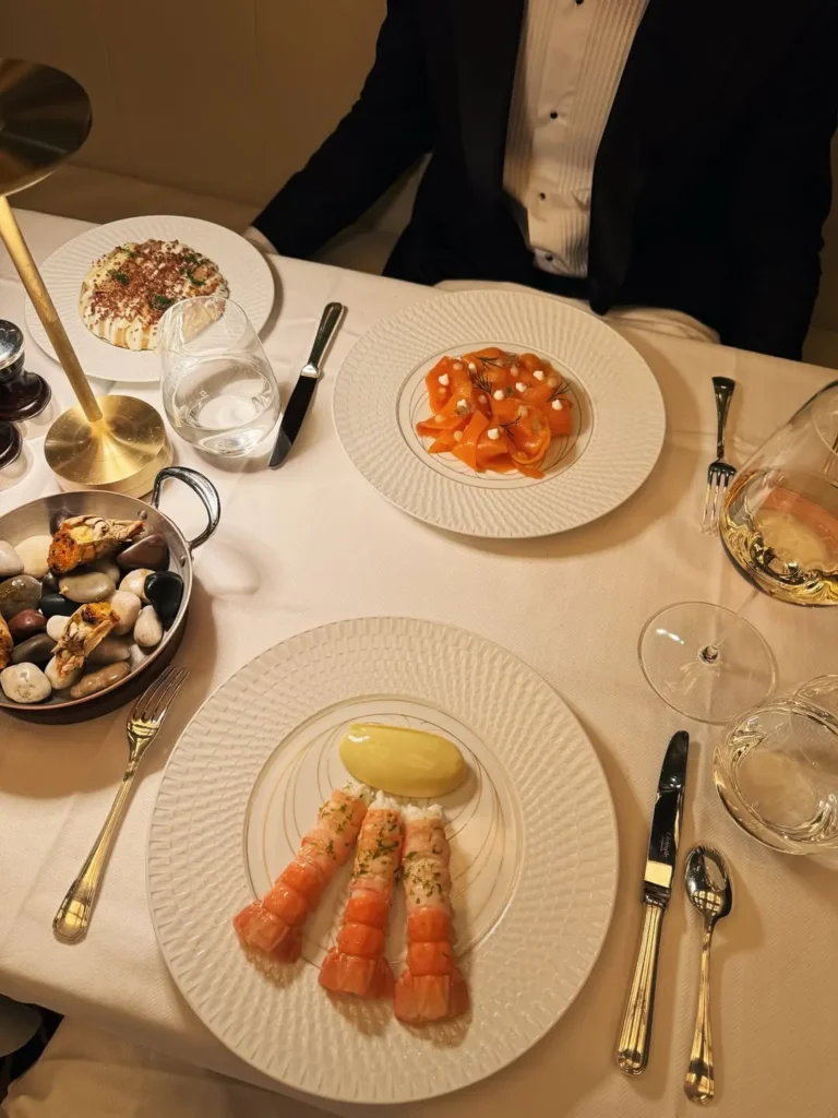 Elegant table setting with gourmet dishes at Le Relais Plaza in Paris