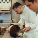 Chef preparing food in the kitchen at Le Relais Plaza in Paris