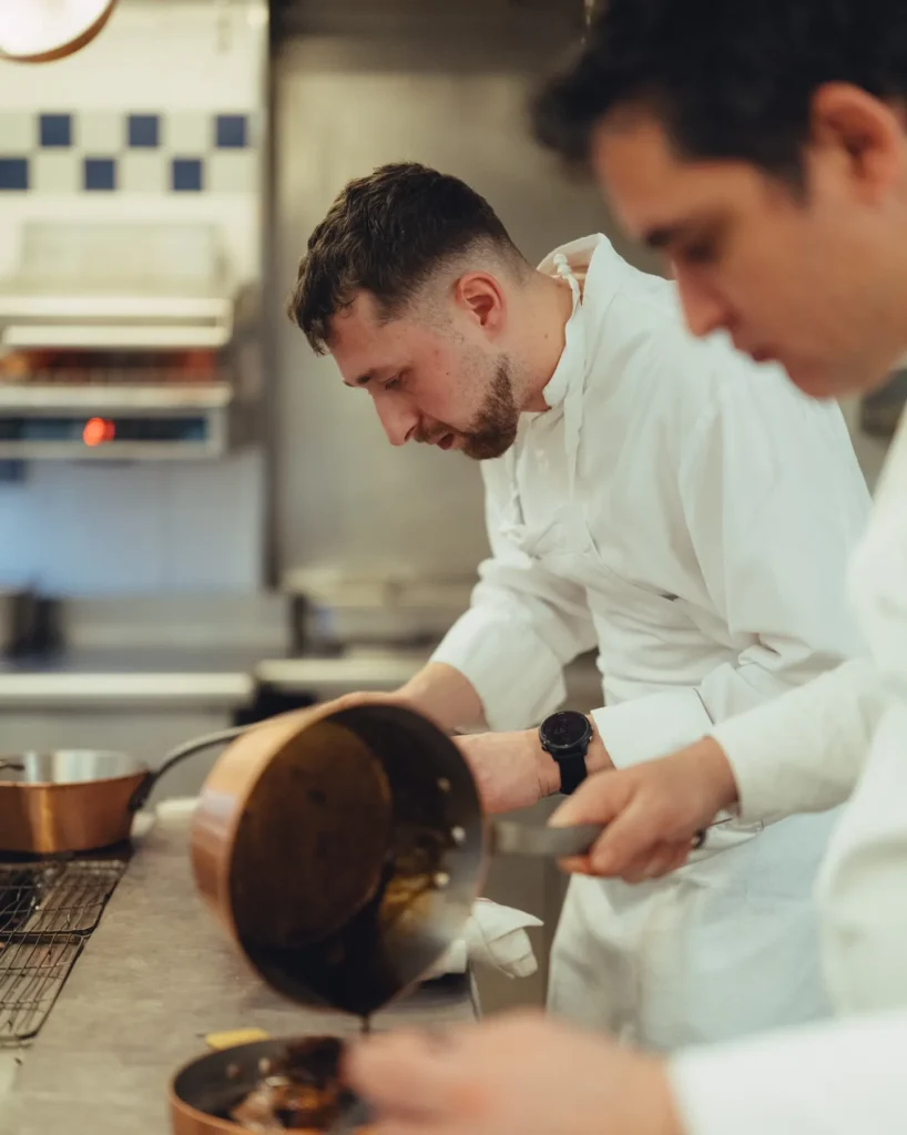Chef preparing food in the kitchen at Le Relais Plaza in Paris