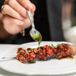 Chef plating a gourmet dish at Le Royal Monceau Paris