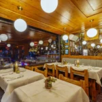 Warm wooden dining area with round lights at Le Tremplin Courchevel