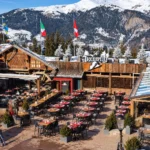 Outdoor dining area at Le Tremplin Courchevel surrounded by snowy mountains