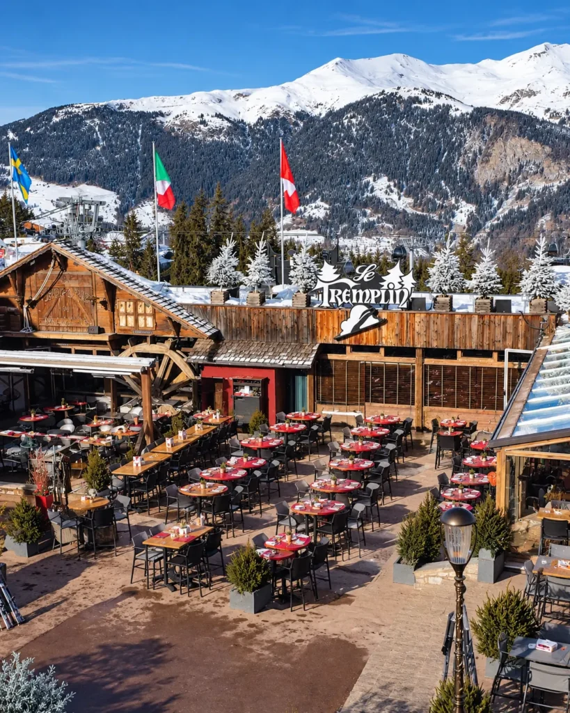 Outdoor dining area at Le Tremplin Courchevel surrounded by snowy mountains