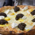 Pizza topped with cheese and black truffle at Le Tremplin Courchevel