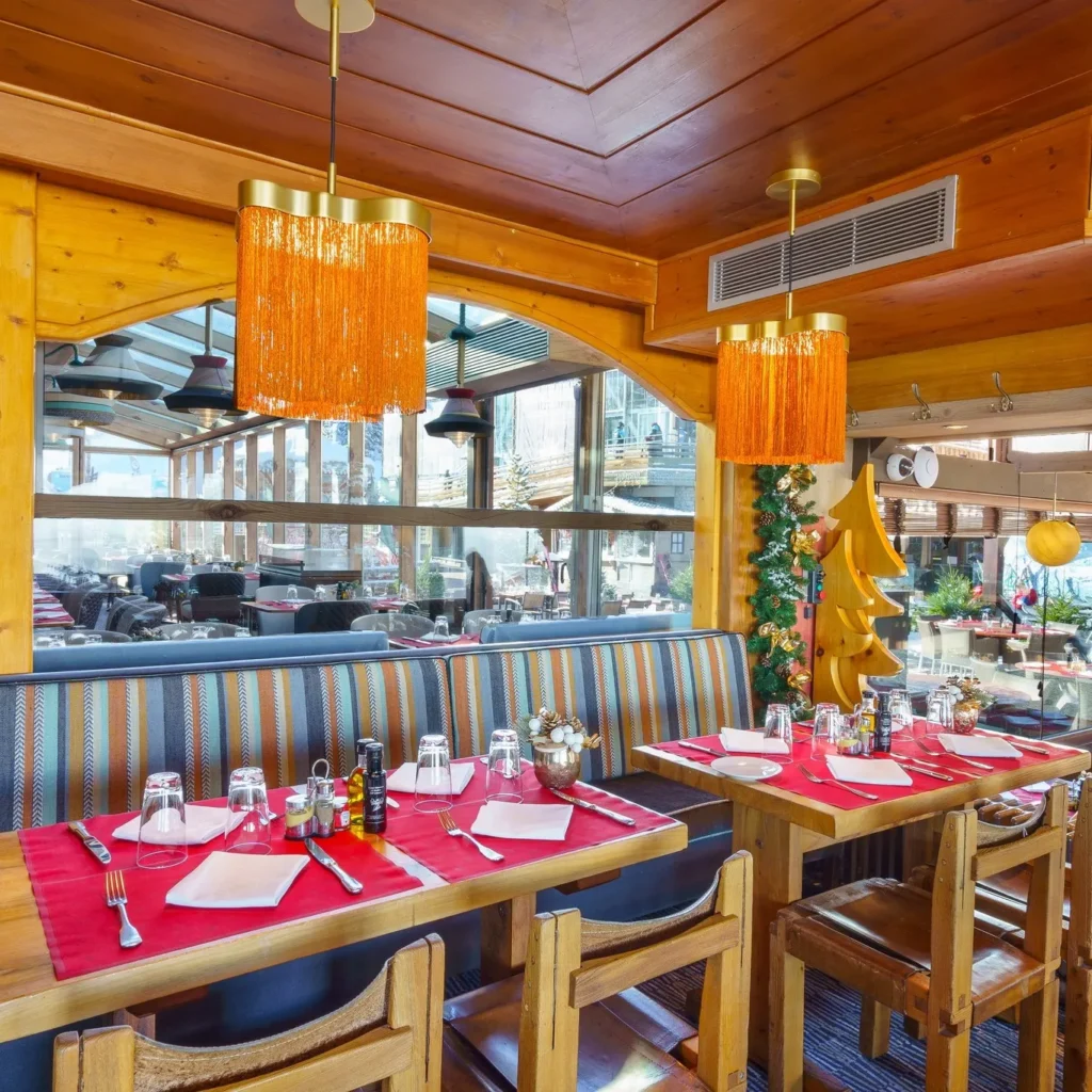 Elegant restaurant interior with red table settings at Le Tremplin Courchevel