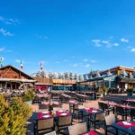 Outdoor terrace dining at Le Tremplin Courchevel under a clear blue sky