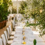 Long outdoor dining table surrounded by greenery at Loulou Paris