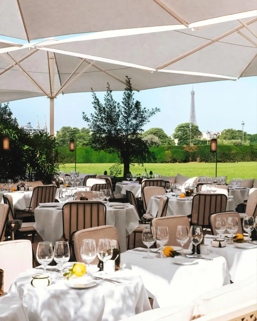 Outdoor dining tables overlooking the gardens at Loulou Paris