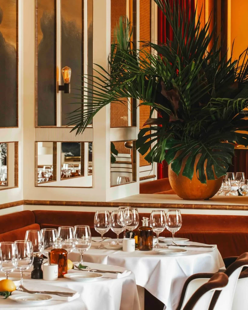 Elegant restaurant interior with greenery at Loulou Paris
