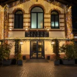 Illuminated exterior entrance of Maison Milano at night