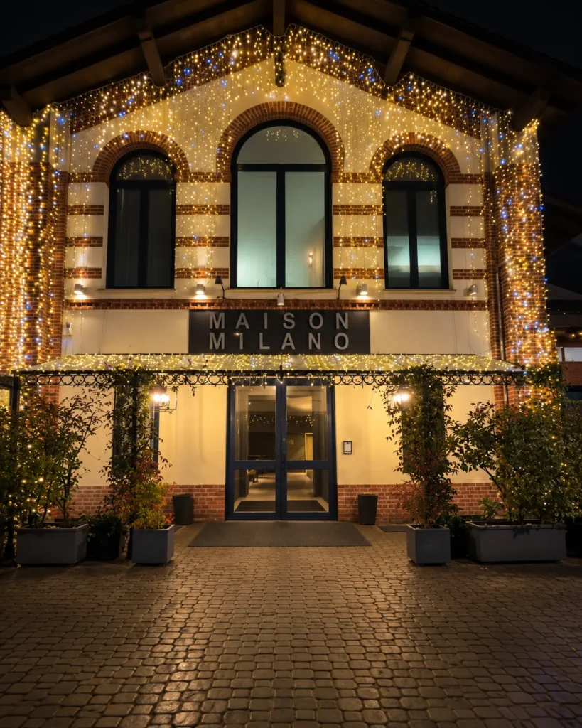 Illuminated exterior entrance of Maison Milano at night