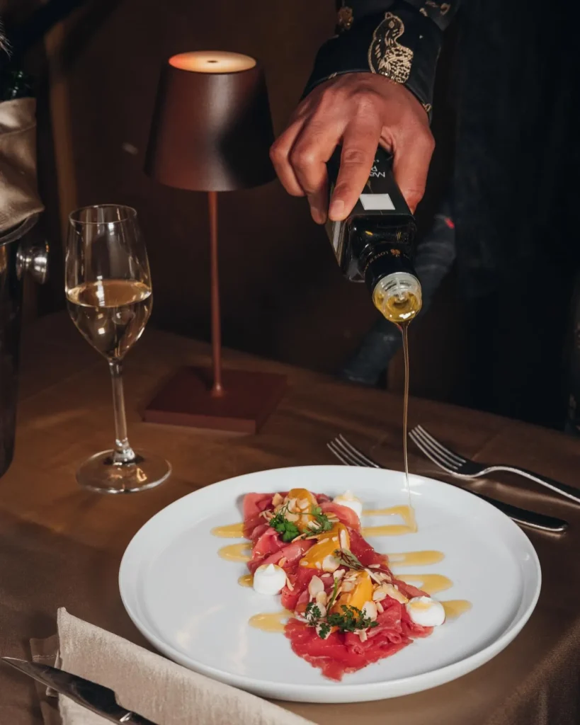 Gourmet dish being served at a table at Maison Milano