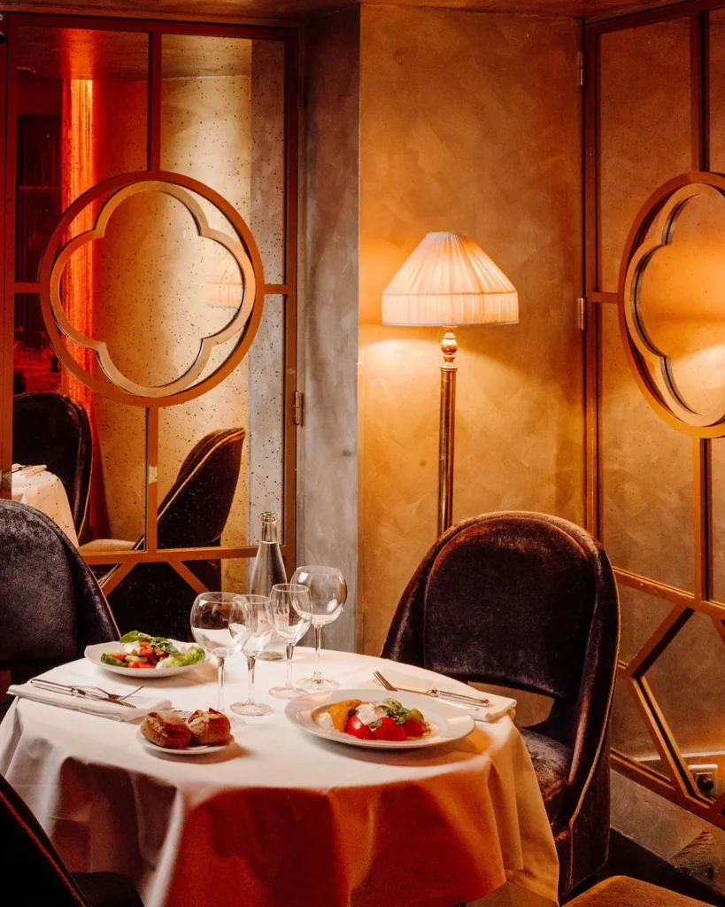 Warmly lit dining area with elegant table settings at Matignon Paris