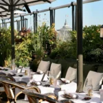 Outdoor dining tables surrounded by greenery at MUN Paris