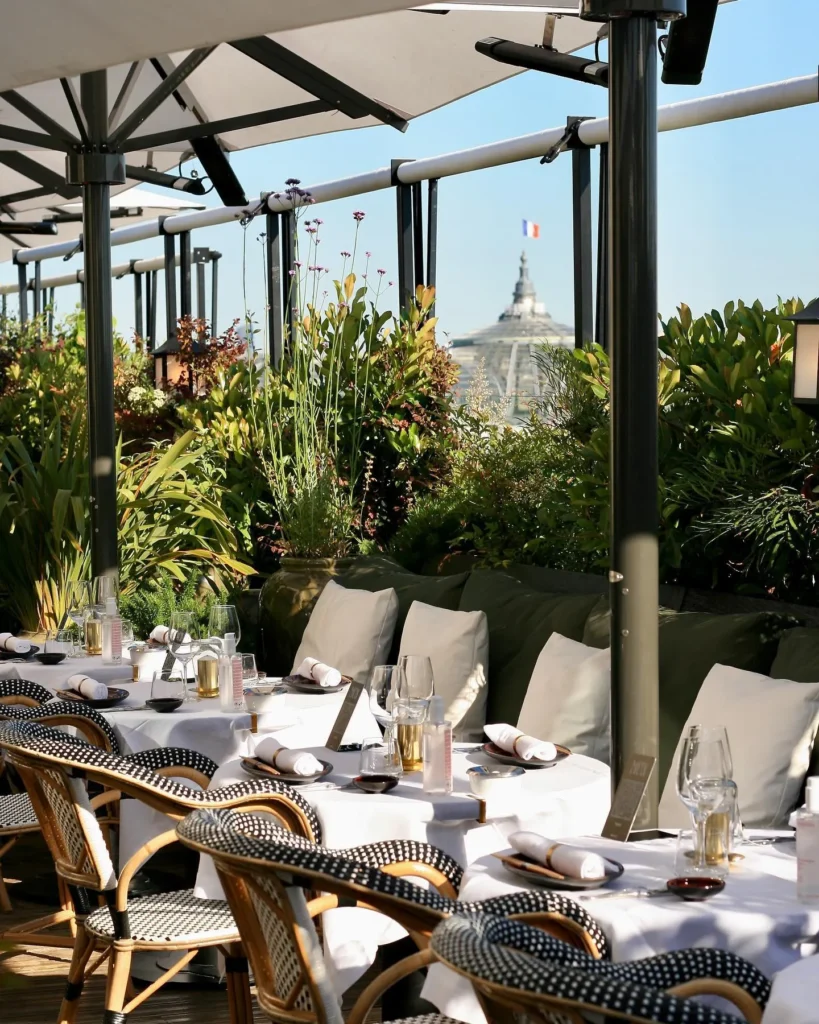 Outdoor dining tables surrounded by greenery at MUN Paris