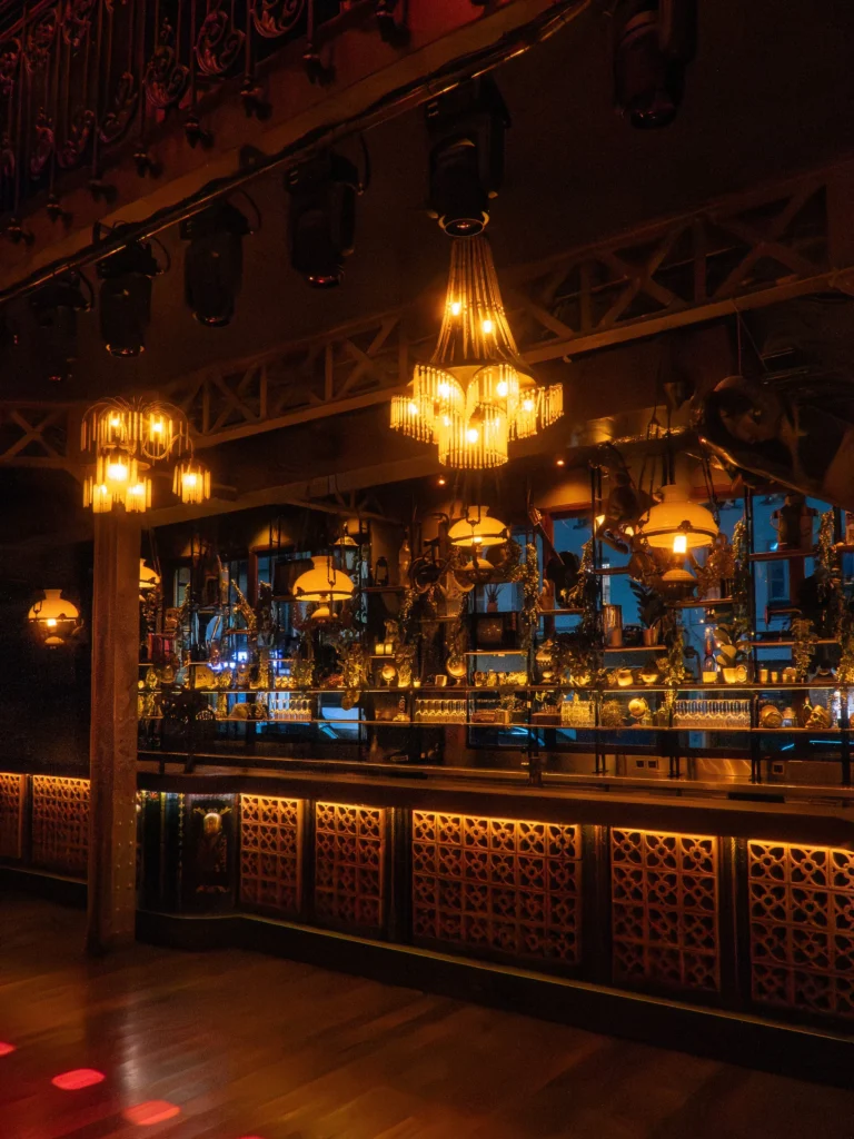 Elegant bar with illuminated bottles and warm lighting at Pachamama Paris