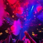 Guests dancing under colorful lights at Pachamama Paris
