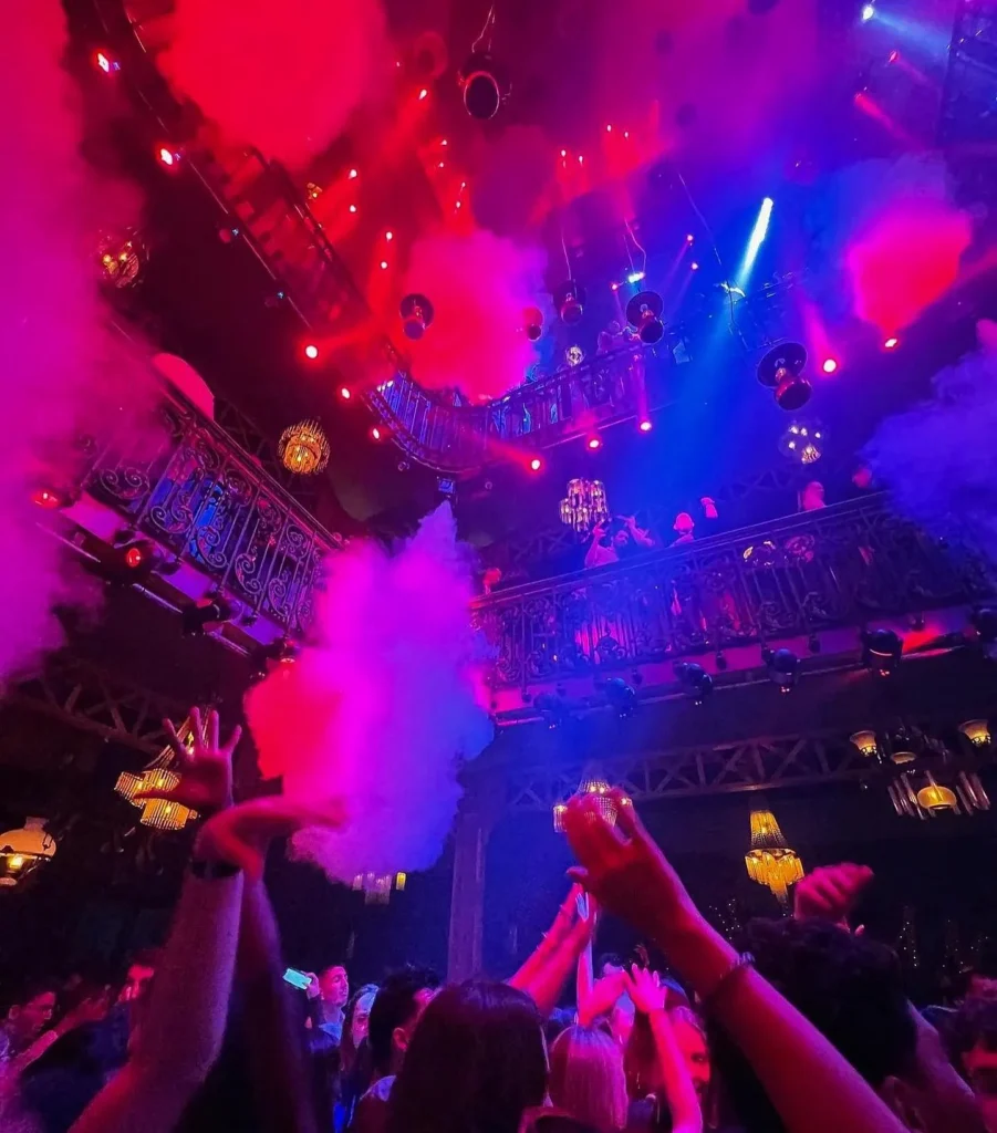 Guests dancing under colorful lights at Pachamama Paris
