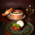 Gourmet plated dish served with wine at Pachamama Paris