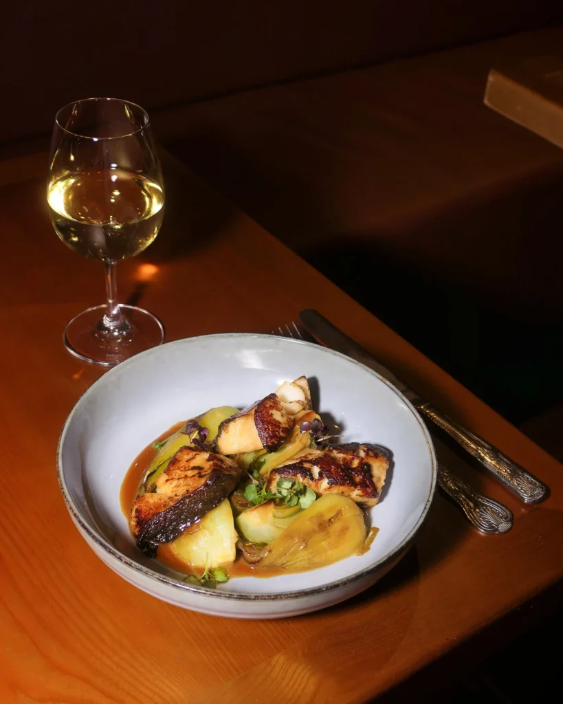 Gourmet plated dish served with wine at Pachamama Paris