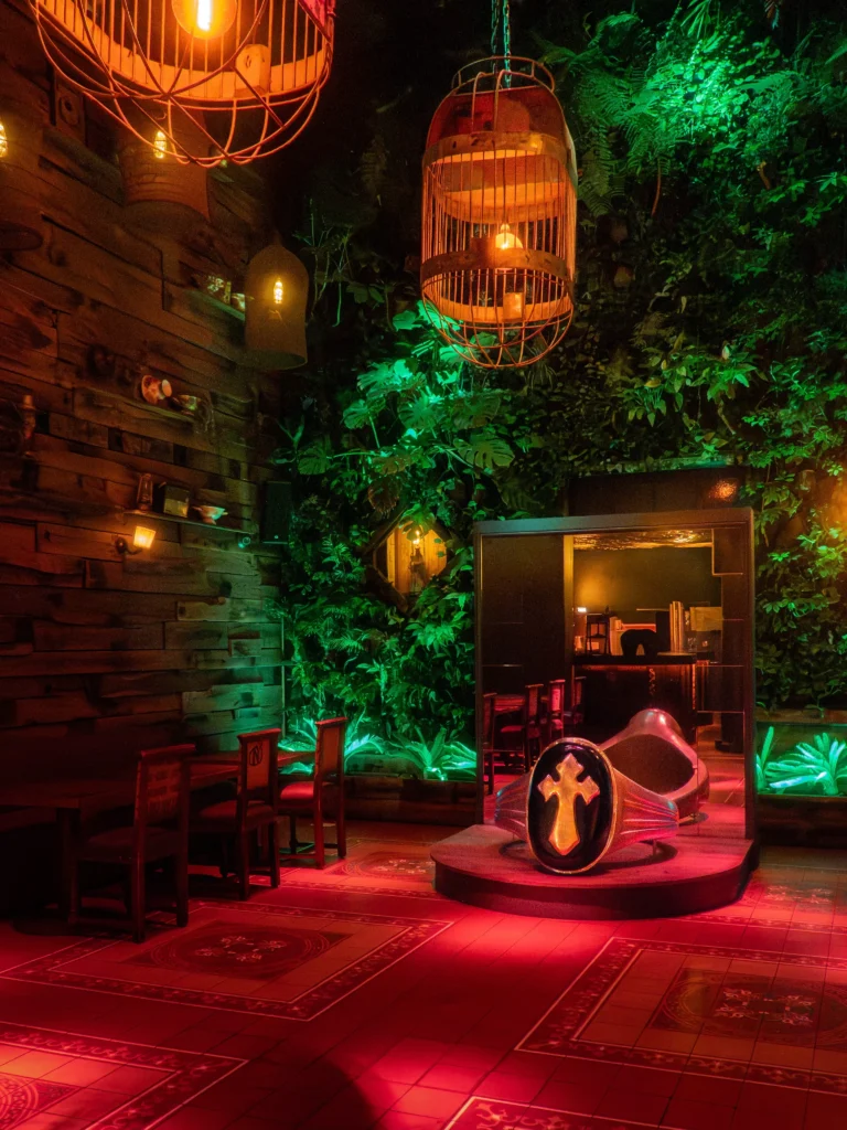 Colorfully lit lounge area with greenery inside Pachamama Paris
