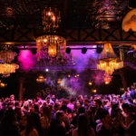 Crowd enjoying a lively night with colorful lighting at Pachamama Paris