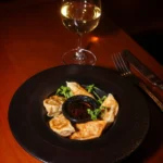 Plated gourmet dish served with wine at Pachamama Paris