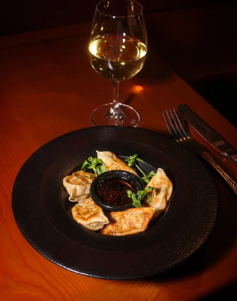 Plated gourmet dish served with wine at Pachamama Paris