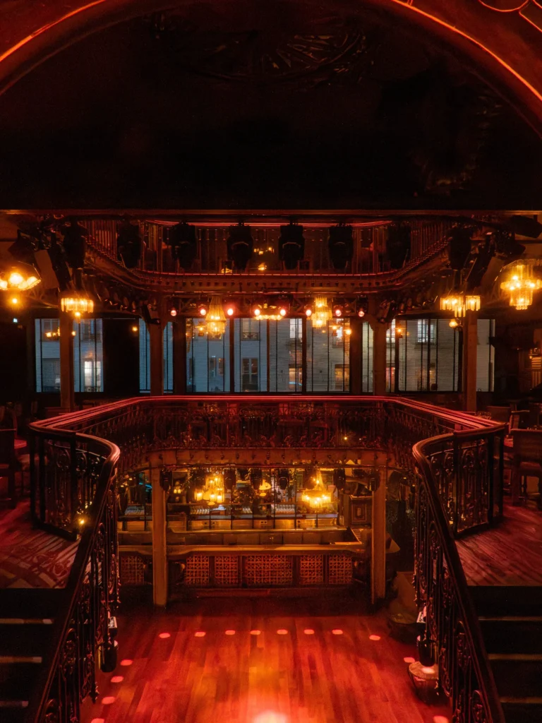 Illuminated stage and balcony inside Pachamama Paris