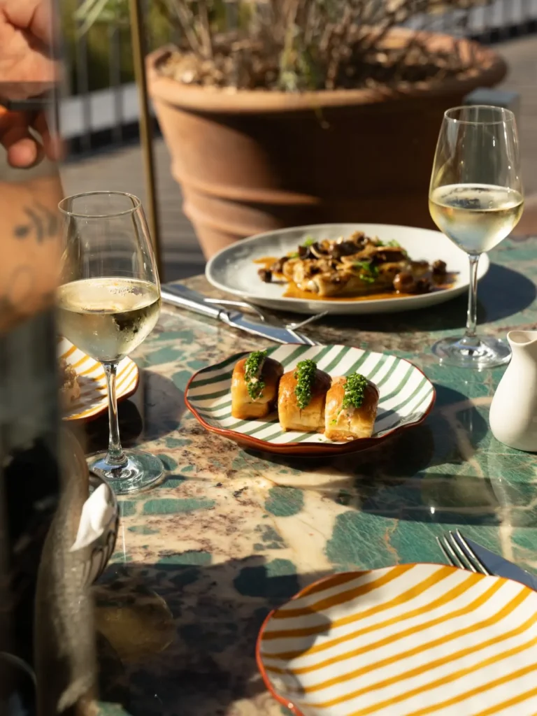 Food and wine arranged on a table at Perruche Paris