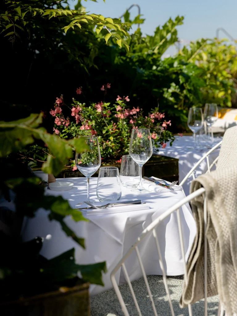 Elegant outdoor dining table surrounded by greenery at Perruche Paris