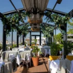Outdoor dining tables on the rooftop terrace at Perruche Paris